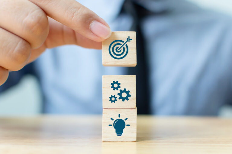 businessman-putting-wooden-block-on-top-with-icons (1)